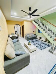 a living room with a couch and a staircase at Cozy Kulai Retreat 5Min AeonPalm Resort15Min Senai airport in Kulai