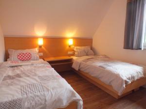 1 Schlafzimmer mit 2 Betten und 2 Leuchten an der Wand in der Unterkunft Ferienhaus Moni mit 2 separaten Wohnungen am Silbersee in Frielendorf