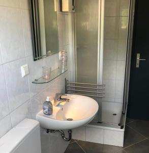 a white bathroom with a sink and a shower at Ferienhaus Moni mit 2 separaten Wohnungen am Silbersee in Frielendorf