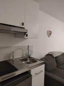 a kitchen with a sink and a couch at CHALET CLUB VAL CLARET in Tignes