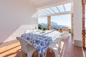 een witte eetkamer met een tafel en witte stoelen bij Casa Lia e Nino a San Vito Lo Capo in San Vito lo Capo