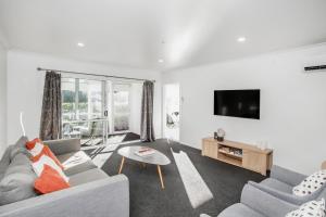 - un salon avec un canapé et une télévision dans l'établissement Quality City Appartment, à Christchurch