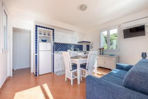 cocina y sala de estar con mesa y sofá azul en Casa Lia e Nino a San Vito Lo Capo en San Vito lo Capo