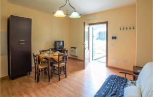 comedor con mesa, sillas y TV en 2 Bedroom Gorgeous Apartment In Todiano Di Preci 