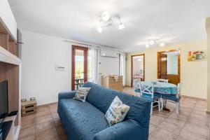sala de estar con sofá azul y mesa en Casa Oleandro en Buggerru