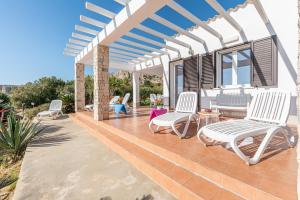 d'une terrasse avec des chaises blanches et une pergola. dans l'établissement Casa Lia e Nino a San Vito Lo Capo, à San Vito Lo Capo