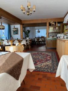 ein Restaurant mit Tischen und Stühlen und ein Esszimmer in der Unterkunft Ciasa Soreghina in Kolfuschg