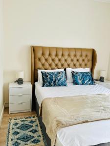 a bedroom with two beds with a tufted headboard at Moc Luxury Apartment in Johannesburg