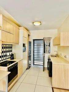 a kitchen with wooden cabinets and a black appliance at Moc Luxury Apartment in Johannesburg