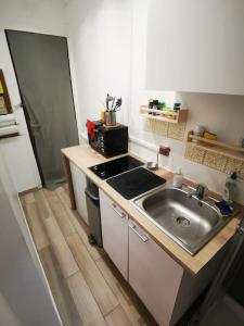 eine kleine Küche mit einer Spüle und einem Herd in der Unterkunft Cozy Studio*Near Paris*Ideal Couple in Boulogne-Billancourt