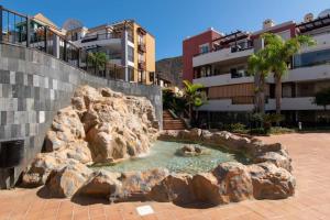 a artificial rock pool in front of a building at Villa with private pool and beautiful garden in Los Cristianos