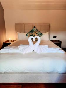 two swans making a heart on a bed at Longstone Bed & Breakfast in Challacombe