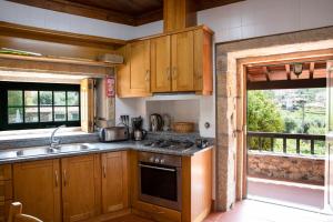 eine Küche mit Holzschränken und einem Herd mit Backofen in der Unterkunft Fonte dos Pepes by LovelyStay in Lamego + 36 Fotos