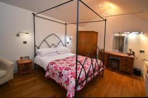 a bedroom with a canopy bed and a desk at Tudor Lodge Bed & Breakfast in Manorbier