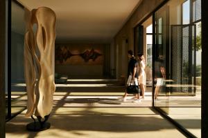 a group of people walking through a building at Minos Beach Art Hotel, a Member of Design Hotels in Agios Nikolaos
