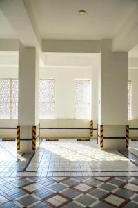 an empty room with windows and a tiled floor at Ghumo - 3BR APT Main Shahrah-e-Faisal in Karachi