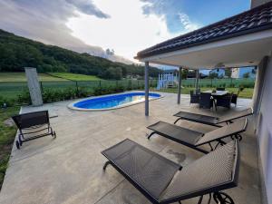 a patio with a table and chairs and a pool at Villa Dora in Krapinske Toplice
