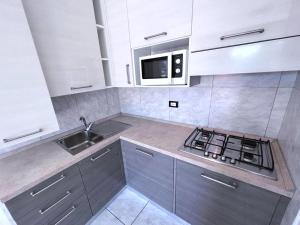 una cucina con piano cottura, lavello e forno a microonde di Residence Villa Regina a Bibione