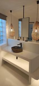 baño con lavabo y 2 lámparas colgantes en Altana Boutique Hotel en Tinos Town