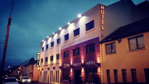 a building with a hotel sign on the side of it at The Valley Hotel & Carriage Gardens in Fivemiletown
