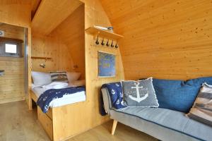 a room with a couch and a bed in a cabin at Hausboot Störtebecker in Gager