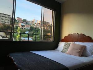 a bedroom with a bed with a large window at Encantador apartahotel en el centro de San Gil in San Gil