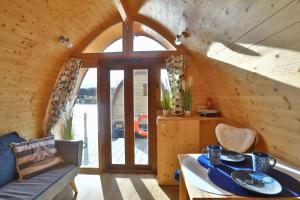 una habitación con una mesa y un sofá en una cabaña en Hausboot Dotterbart, en Gager