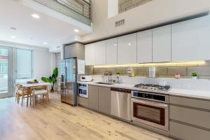 a kitchen with stainless steel appliances and a table at Modern Loft-Style Townhouse in Los Angeles in Los Angeles