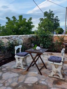 a picnic table and two chairs sitting on a patio at One bedroom house with enclosed garden and wifi at Parada in Parada