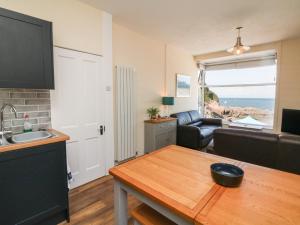 a kitchen and living room with a view of the ocean at At the Bay Apartment in Ilfracombe