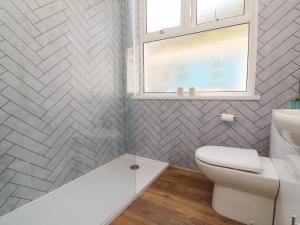 a bathroom with a white toilet and a window at At the Bay Apartment in Ilfracombe