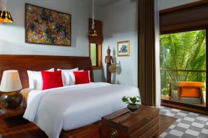 une chambre avec un grand lit blanc avec des oreillers rouges dans l'établissement Sokkhak Boutique Resort & Spa, à Siem Reap 90 autres photos