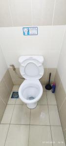 a bathroom with a toilet with a sign on the wall at Homestay Tawau in Tawau