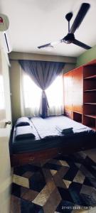 a bedroom with a bed with a window at Homestay Tawau in Tawau