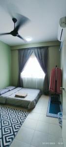 a bedroom with a bed and a window at Homestay Tawau in Tawau