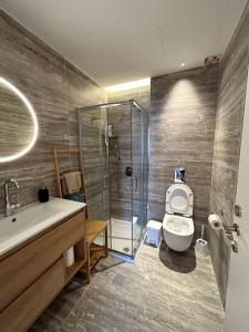 a bathroom with a shower and a toilet and a sink at panoramic apartment EdenTower in Bat Yam