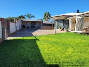 a house with a green lawn in front of it at Meerkat Manor Self-Catering & Accommodation Windhoek in Windhoek