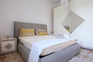 una camera da letto con un letto e un grande specchio di Villetta la pineta a Lequile