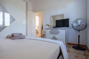 - une chambre blanche avec un lit blanc et un ventilateur dans l'établissement Villetta la pineta, à Lequile
