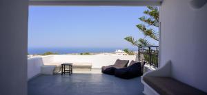 a living room with a couch and a table on a balcony at Fira Vista Hotel in Fira