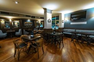 a restaurant with tables and chairs and a television on the wall at Amérian Executive Córdoba Hotel in Córdoba