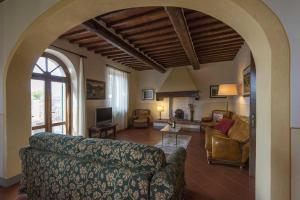 un salon avec un canapé et un salon avec une cheminée dans l'établissement Villa Le Gallozzole, à Quercegrossa