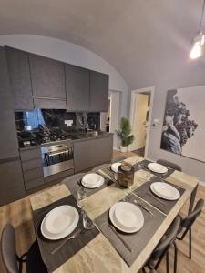 a kitchen with a dining table with chairs and a kitchen with a stove at Casa Bonsai in Turin