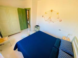 Sa Suergia Apartment في فيلاسيميوس: غرفة نوم بسرير ازرق وطاولة زرقاء