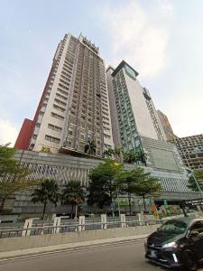 a car parked in front of two tall buildings at Taragon Condominiums- KL in Kuala Lumpur