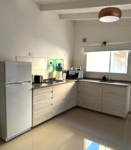a kitchen with a white refrigerator and a stove at Apartamento de las Araucarias in Esquel
