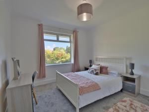 Schlafzimmer mit einem Bett, einem Fenster und einem Schreibtisch in der Unterkunft Seamill Cottage in West Kilbride