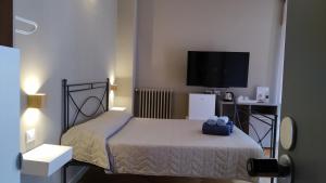 Habitación pequeña con cama y TV de pantalla plana. en Cconforthotels R&B Suite&Chic - SELF CHECK IN en Bari