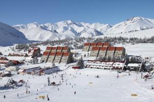 a group of people on a ski slope in the snow at Departamento Boutique Las Leñas ATENAS in Las Lenas