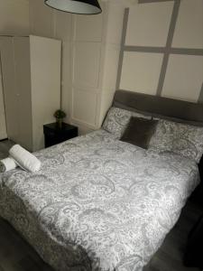 a bedroom with a bed with a gray and white blanket at Central London location, close to bars restaurants and train stations in London
